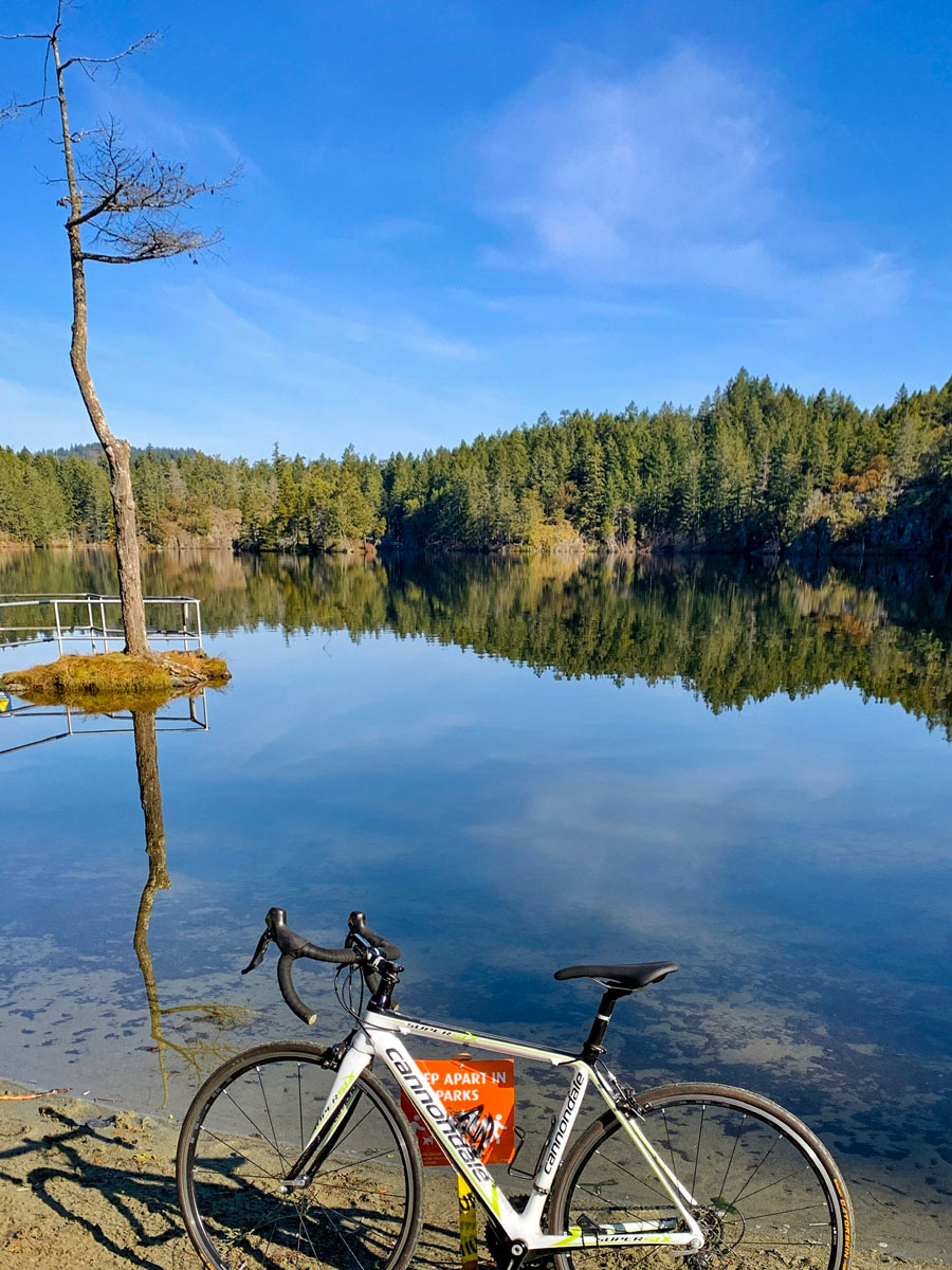 Forest reflection on crystal clear waters of Thetis Lake seen biking from Galloping Goose to Thetis Lake near Victoria