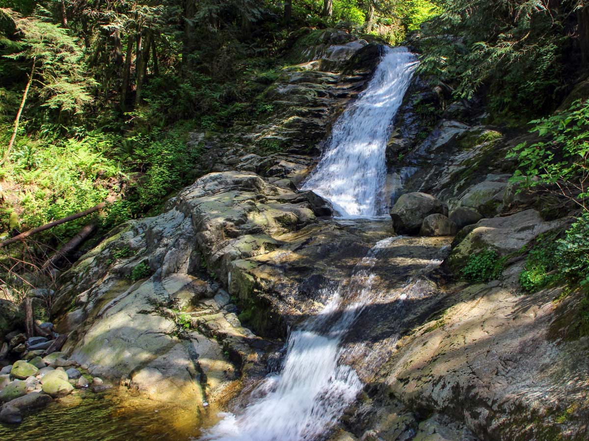 Water tumbles over smooth rocks Crystal Falls waterfall in British Columbia near Vancouver