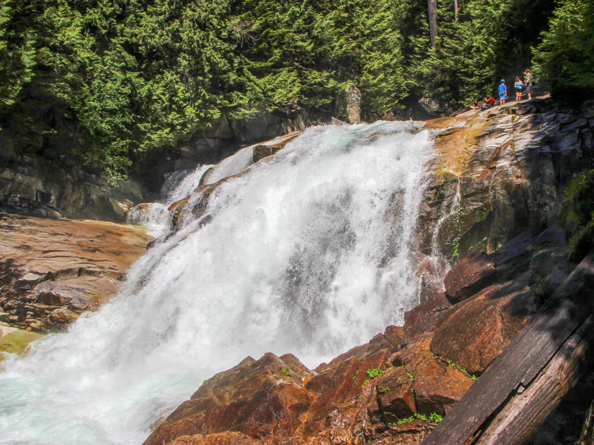 Hikers stand above waterfalls at Gold Creek Falls near Vancouver