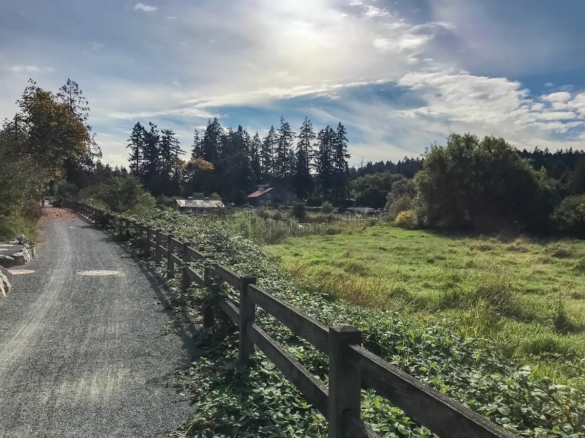 Biking past farmland along Colquitz River Trail near Victoria