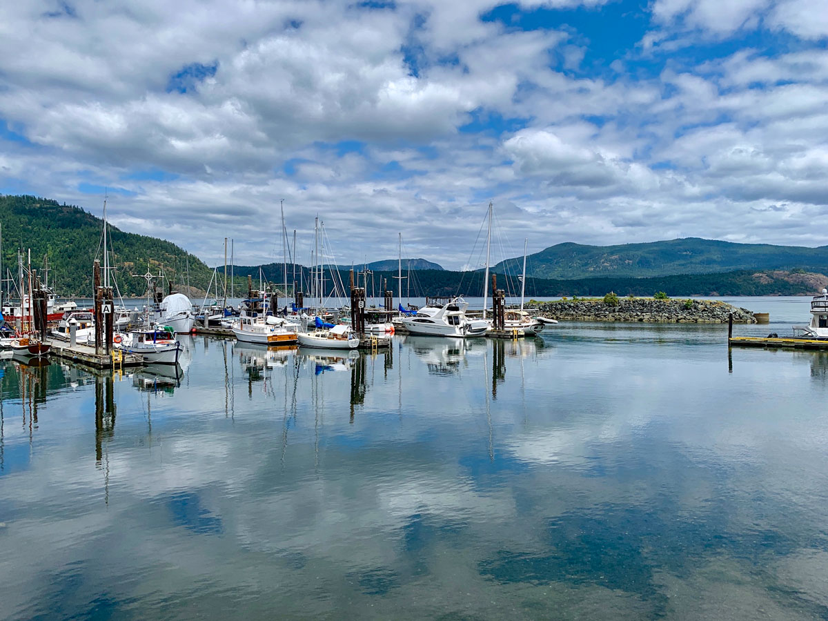 Biking along the harbour of sailboats in Mill Bay