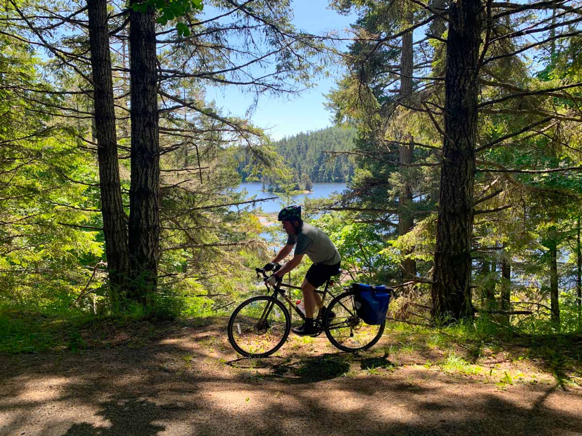 Biker in the shadows along trail Goose to Sooke Potholes near Victoria