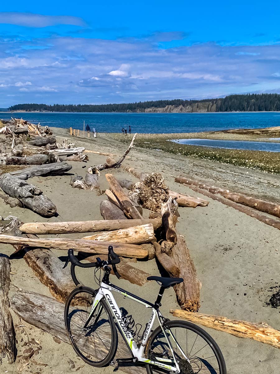 Bikers stop for break on the beach along Lochside Trail near Victoria BC