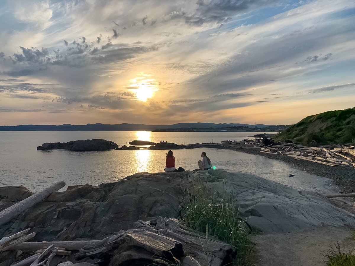 Friends seen watching the sunset from Seaside Loop biking in Victoria BC