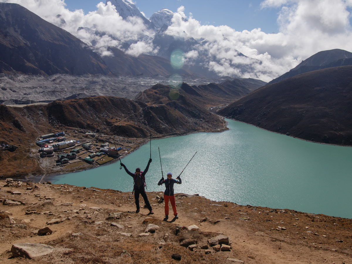 Two hikers posing in front of the lake, along the Three Passes Trek in Nepal