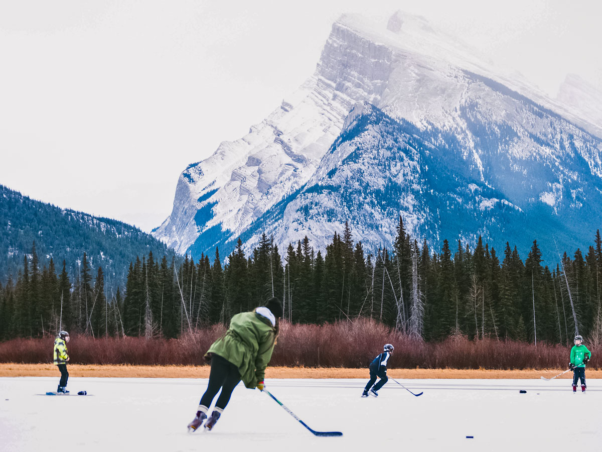 Skating on frozen lake in the Canadian rockies winter near Banff Mt Rundle
