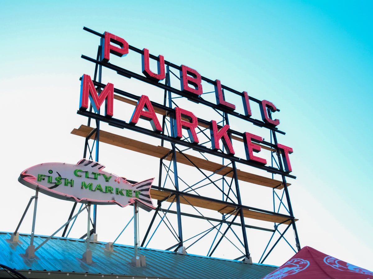 Pike Place Public Market sign on Seattle docks by the Pacific ocean