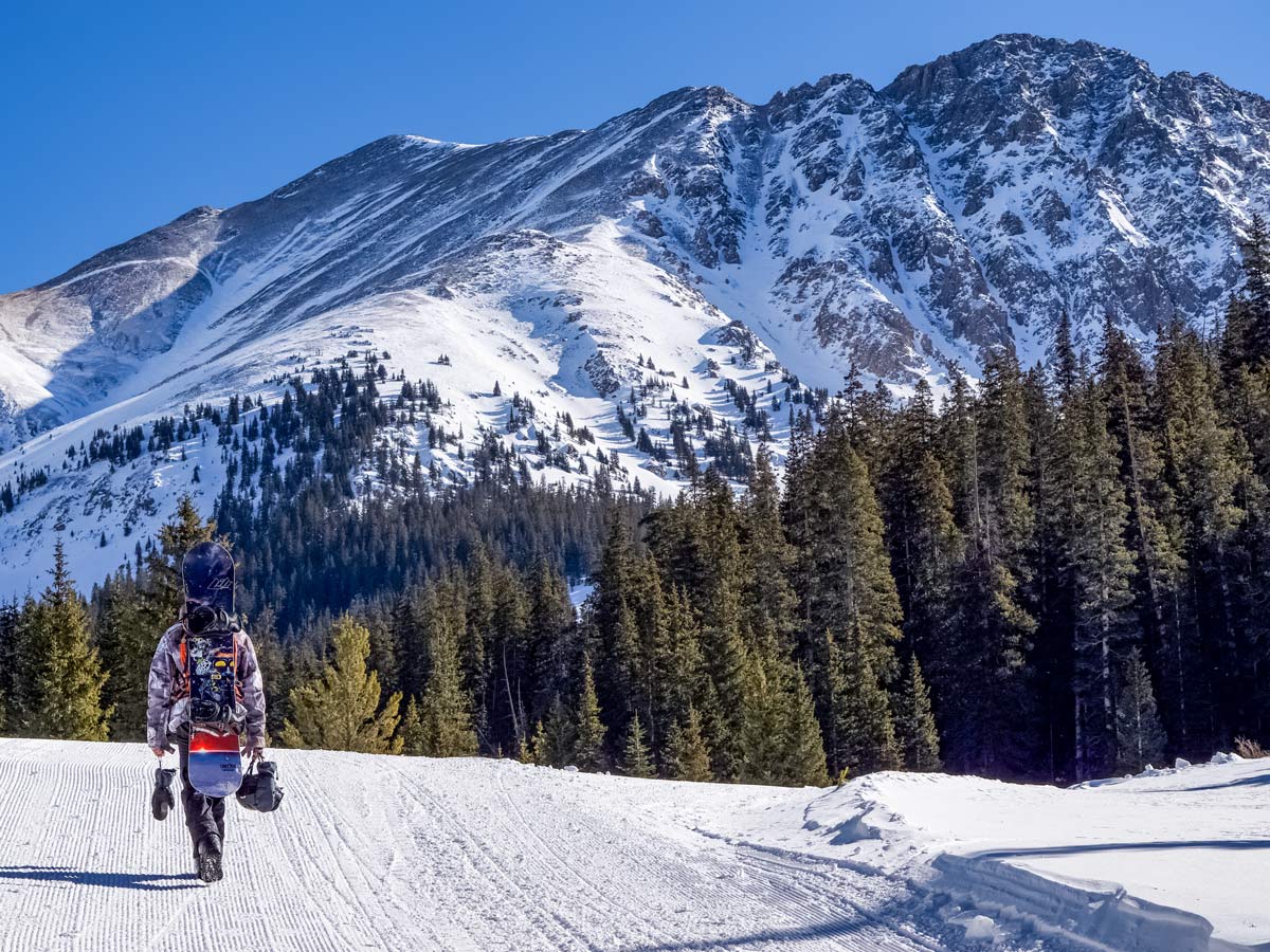 Snowboarder hiking Winter Park Keystone Arapahoe skiing snowboarding Denver Colorado