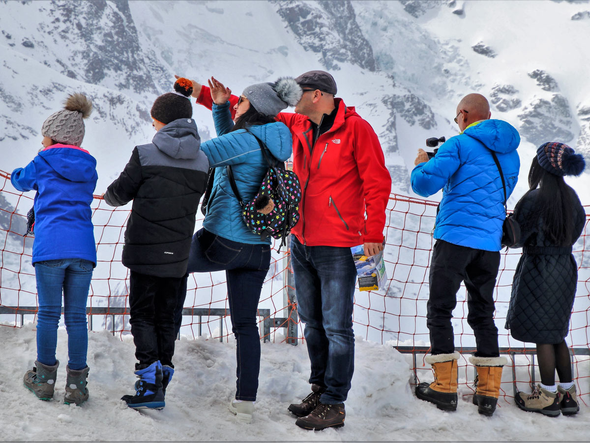 Family winter hiking sightseeing in the snow mountains