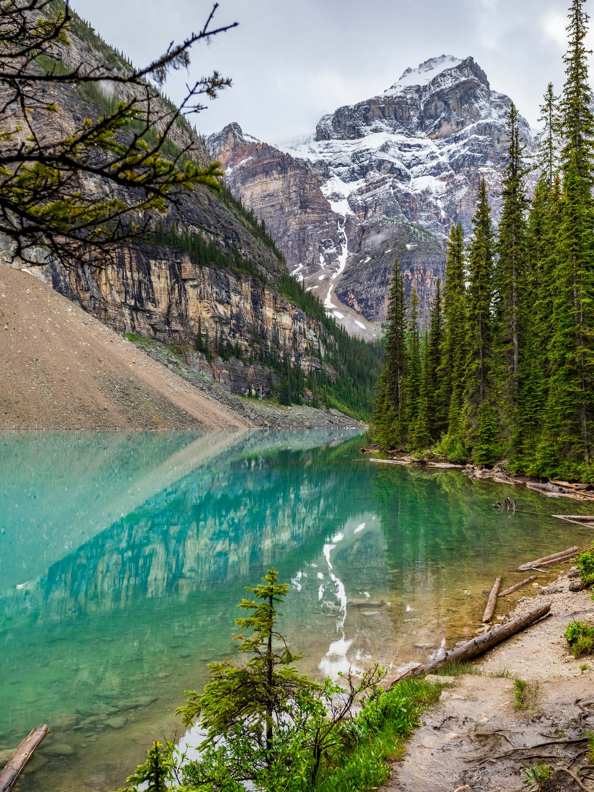 Clear aqua blue emerald green waters fo Moraine Lake hikin gin Banff National Park