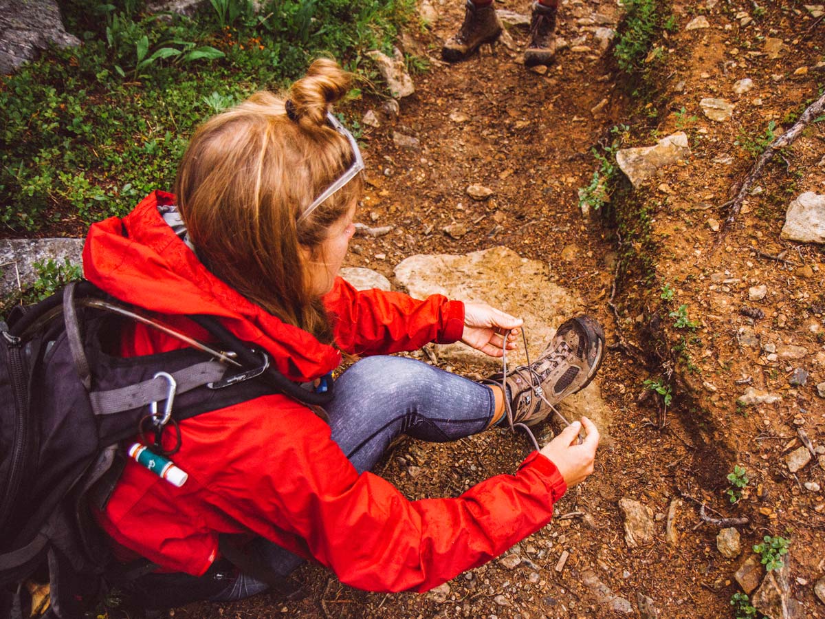 Hiker tying shoelaces on hiking boots