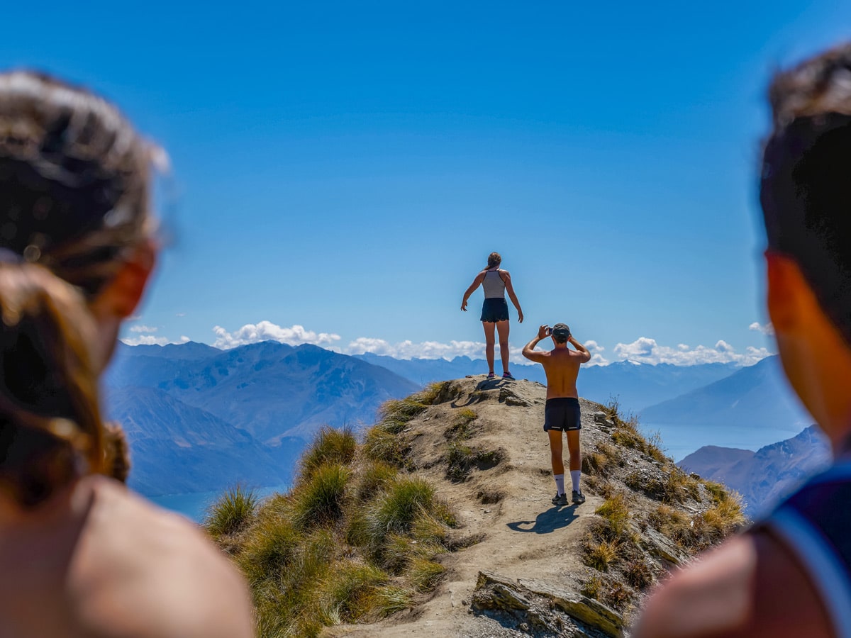 Hikers taking photos on cliff edge