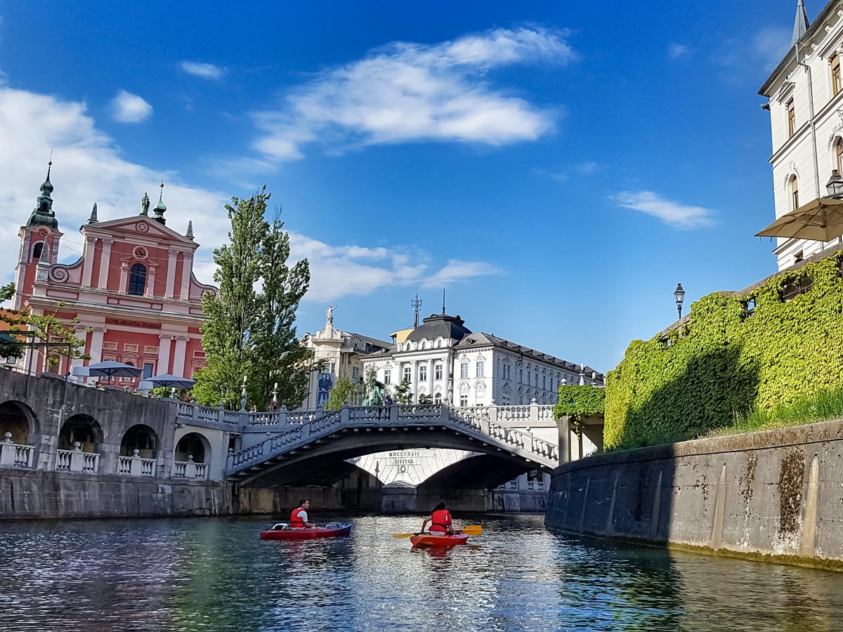 Ljubljana old City bridge and kayakers on the river Slovenia