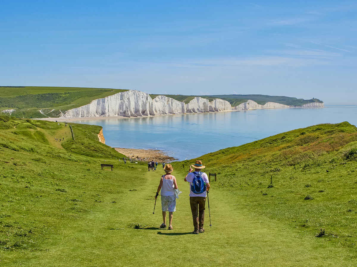 A couple walking towards the Seven Sisters Eastbourne South Downs UK