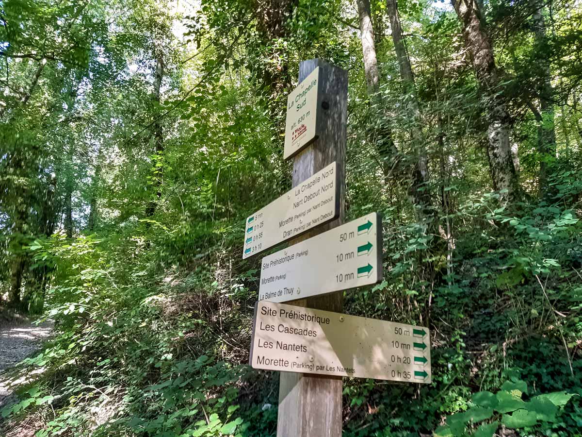 Signpost after prehistoric site hiking Morette Falls trail France
