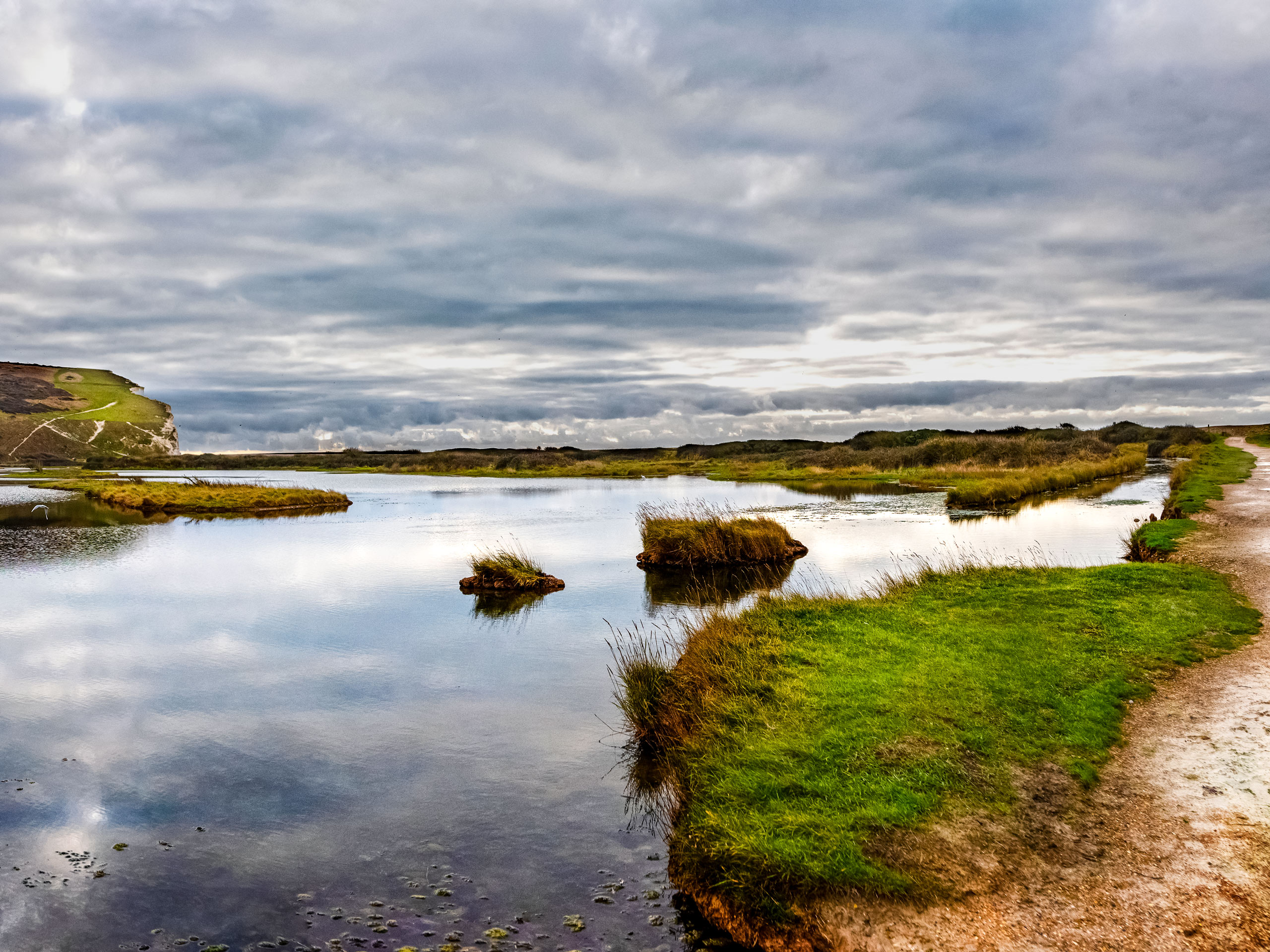 Marsh and walking trail through Cuckmere Valley on a cold winters day