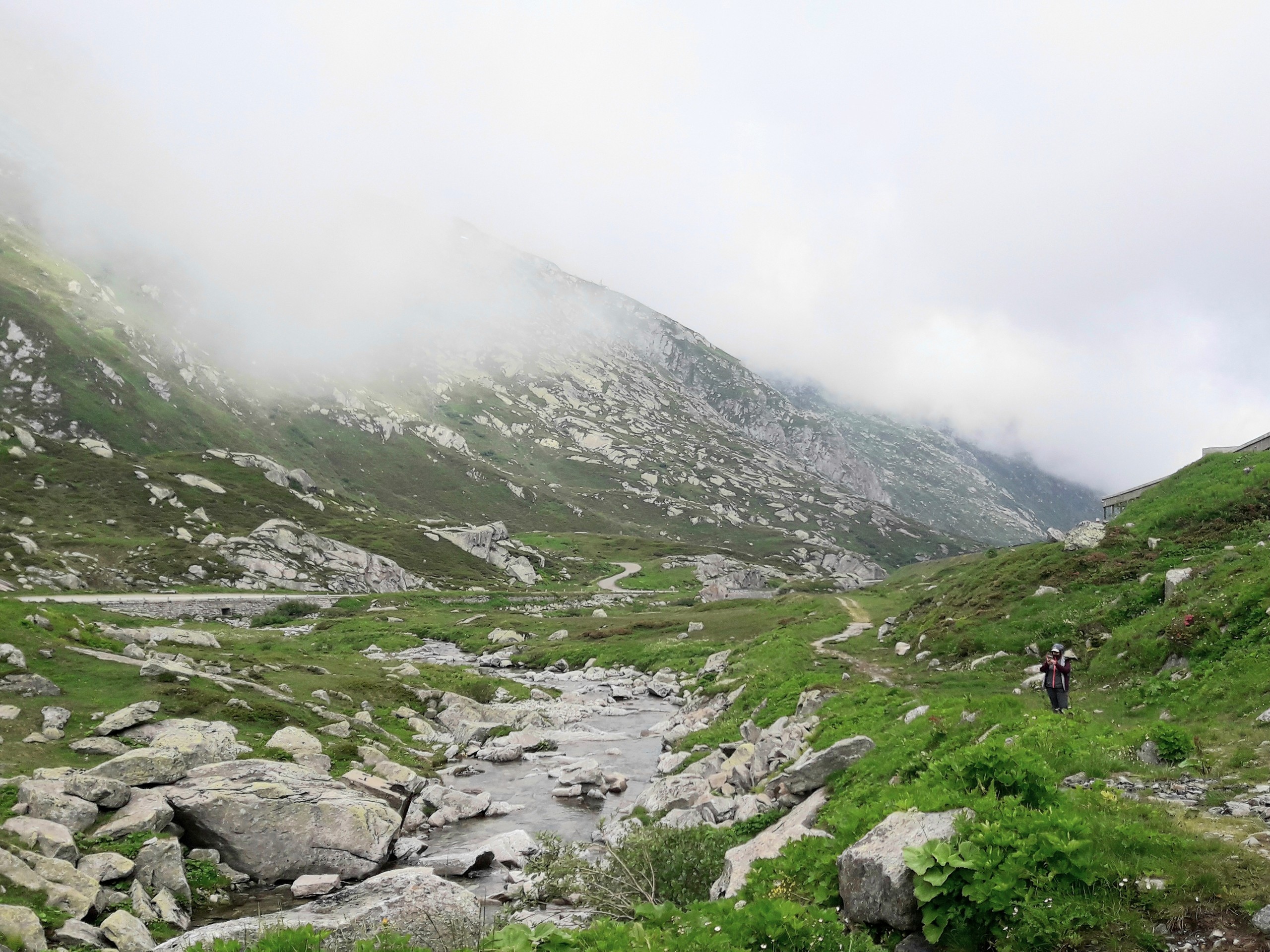 Hiker walking the path from Passo del Gothardo to Hospental in Switzerland