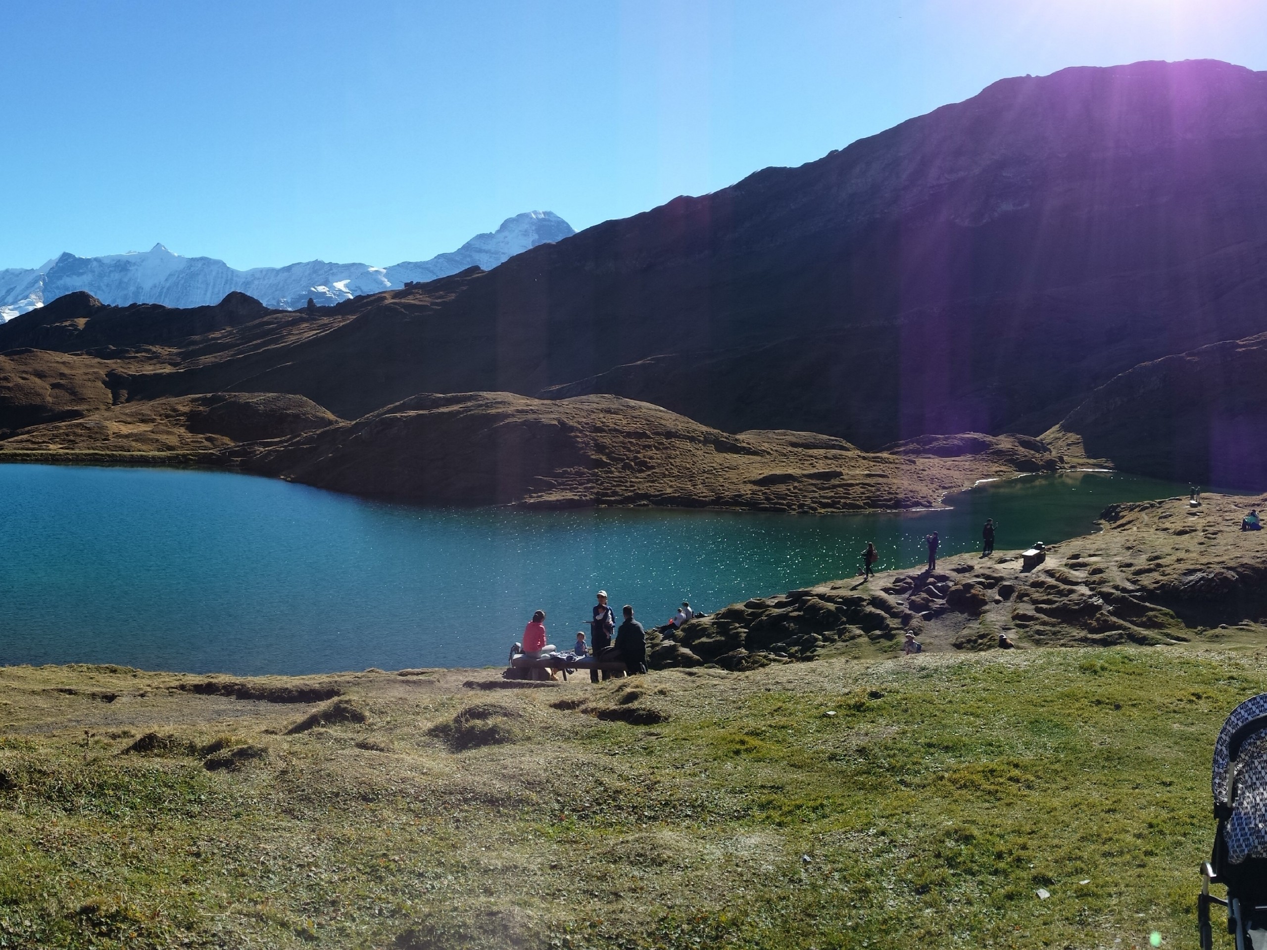 Group of hikers walking along the Lac Bleu in Swiss Alps