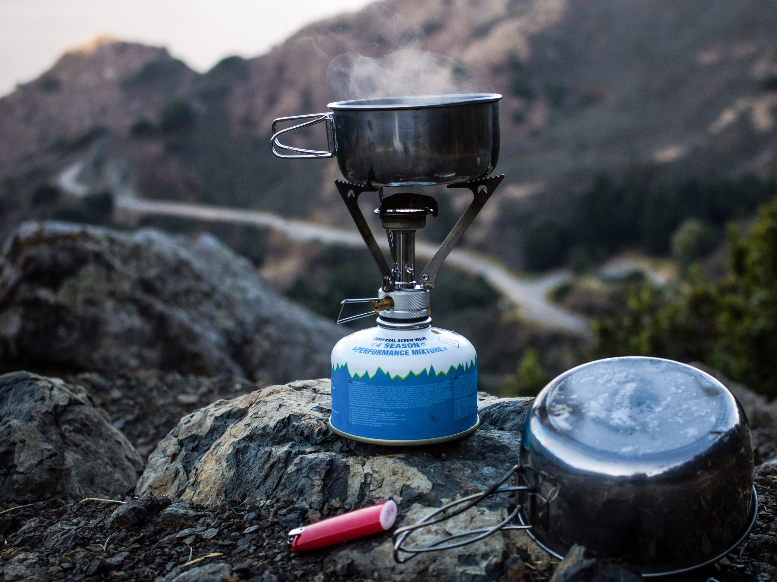 Steam rising from small pot on camp stove backcountry camp kitchen