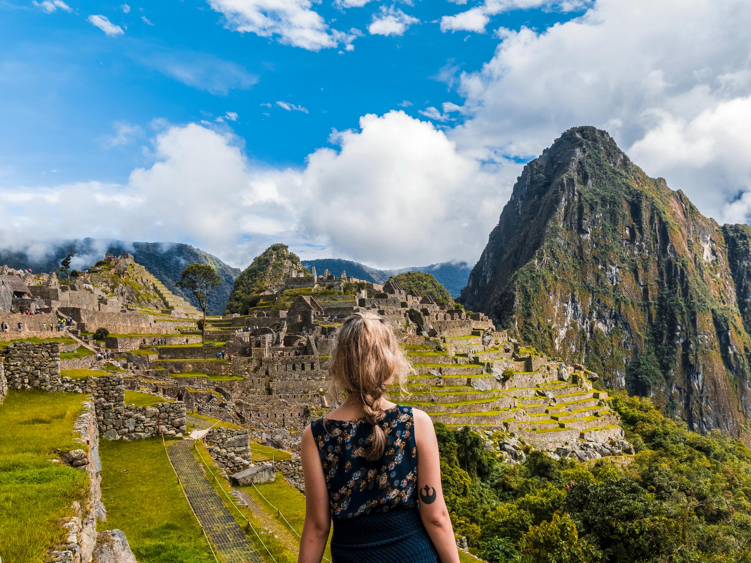 Hiker tourist stands facing ancient Machu Pichhu