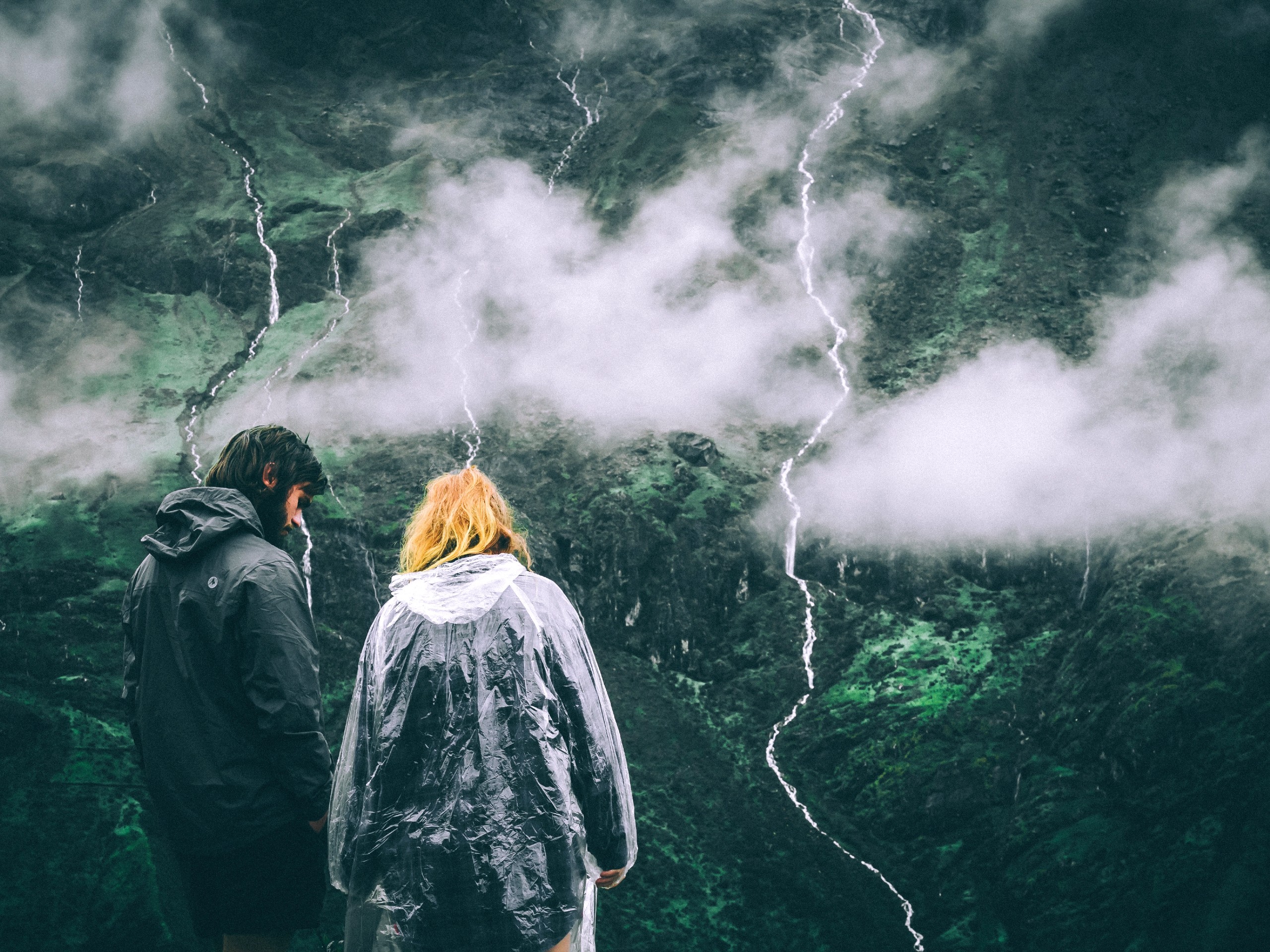 Couple hiking in the mountains during the heavy rain