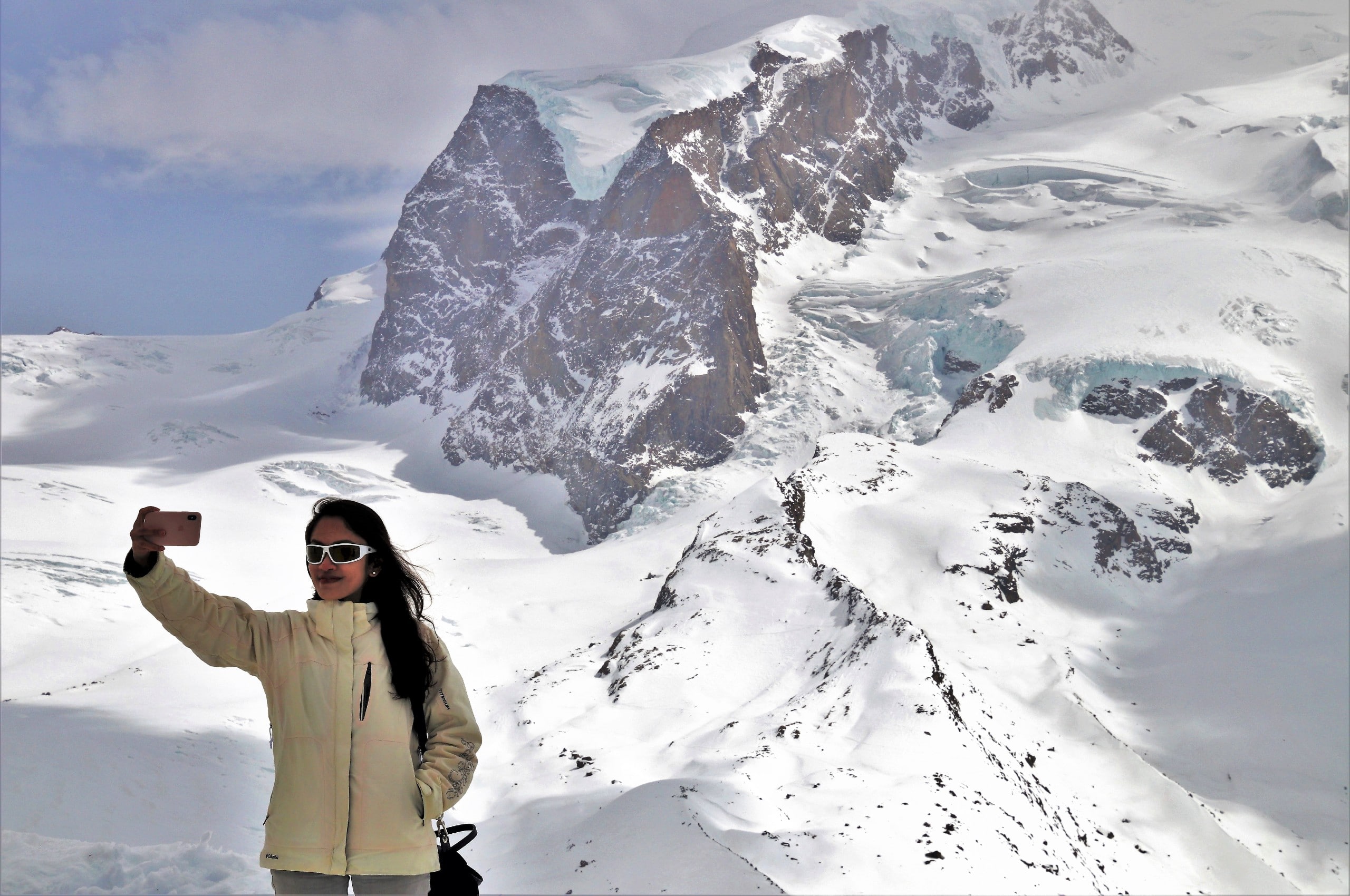 Lady taking a selfie near a snowy mountain range